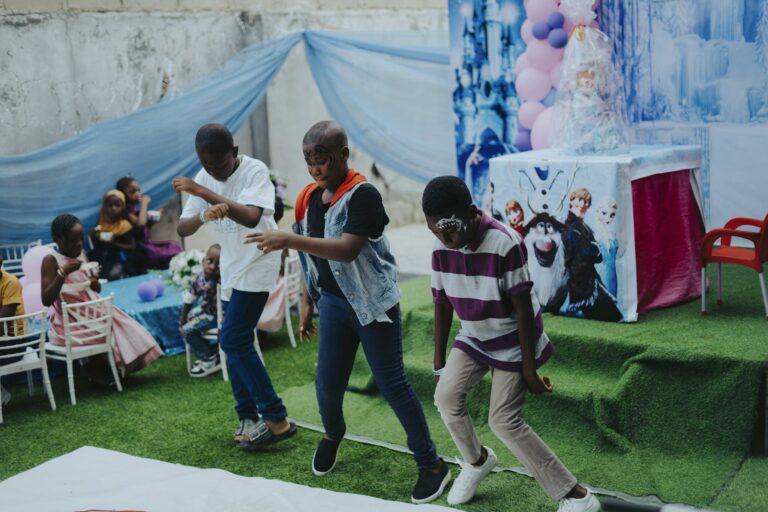 Children dancing at a vibrant birthday party with a Frozen theme, showcasing fun and enjoyment.