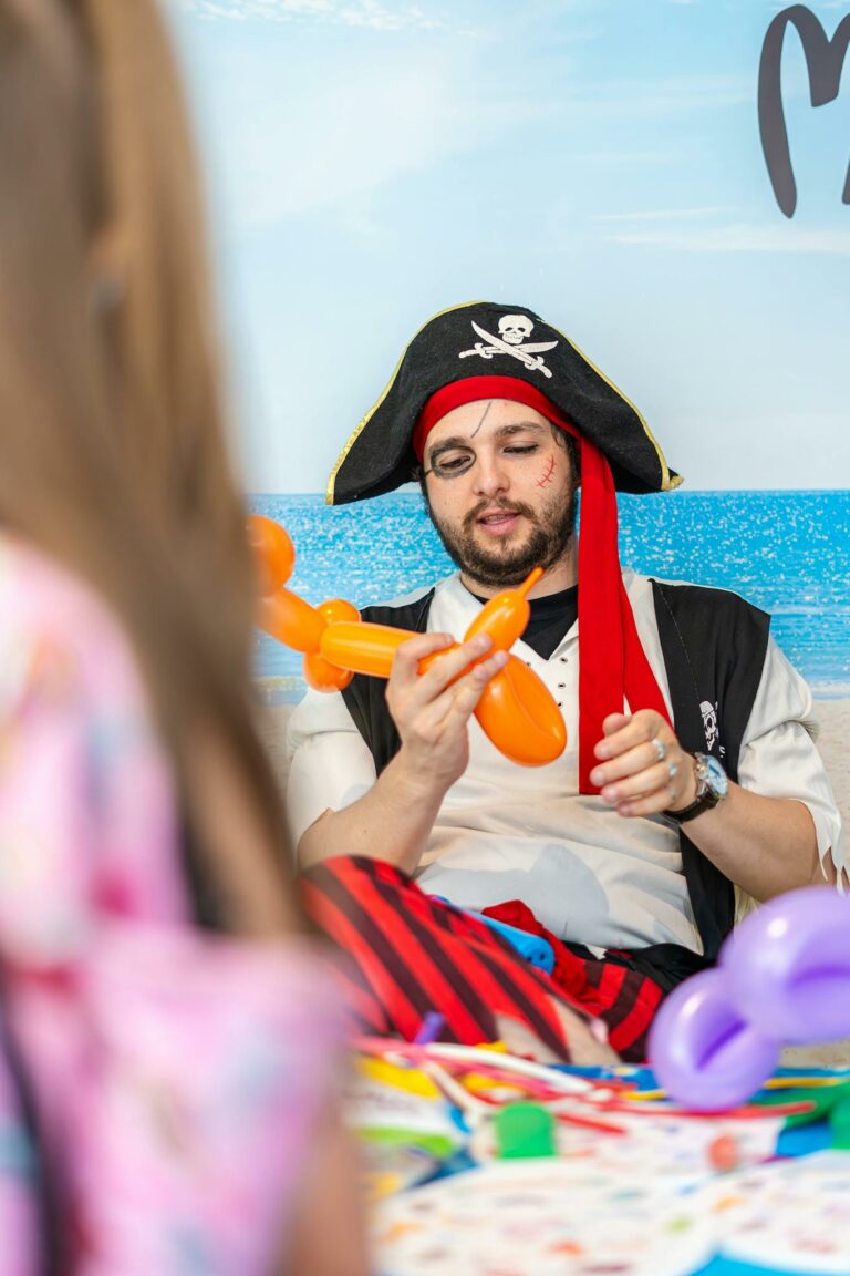 Pirate-themed entertainer creating balloon animals at a children's event.